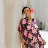 woman wearing an oversized button up shirt dress in dark purple color with orchid print