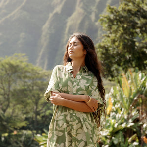 woman with brown hair wearing green collared button up dress with native Hawaiian plants