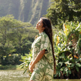 woman with brown hair wearing green collared button up dress with native Hawaiian plants