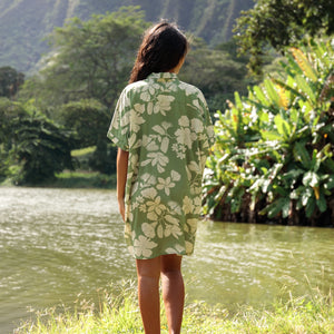 woman with brown hair wearing green collared button up dress with native Hawaiian plants