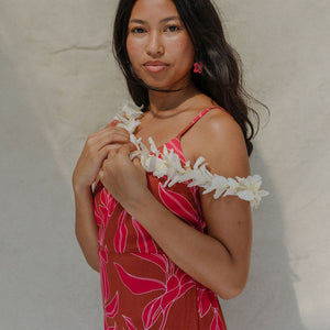 woman with brown hair wearing a sienna colored mini dress with tie back detail and awapuhi pattern