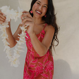 woman with brown hair wearing a sienna colored mini dress with tie back detail and awapuhi pattern