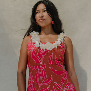 woman with brown hair wearing a sienna colored mini dress with tie back detail and awapuhi pattern