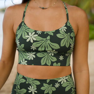 woman with brown hair wearing dark green active sports bra and 4.5 inch shorts with naupaka tiare print