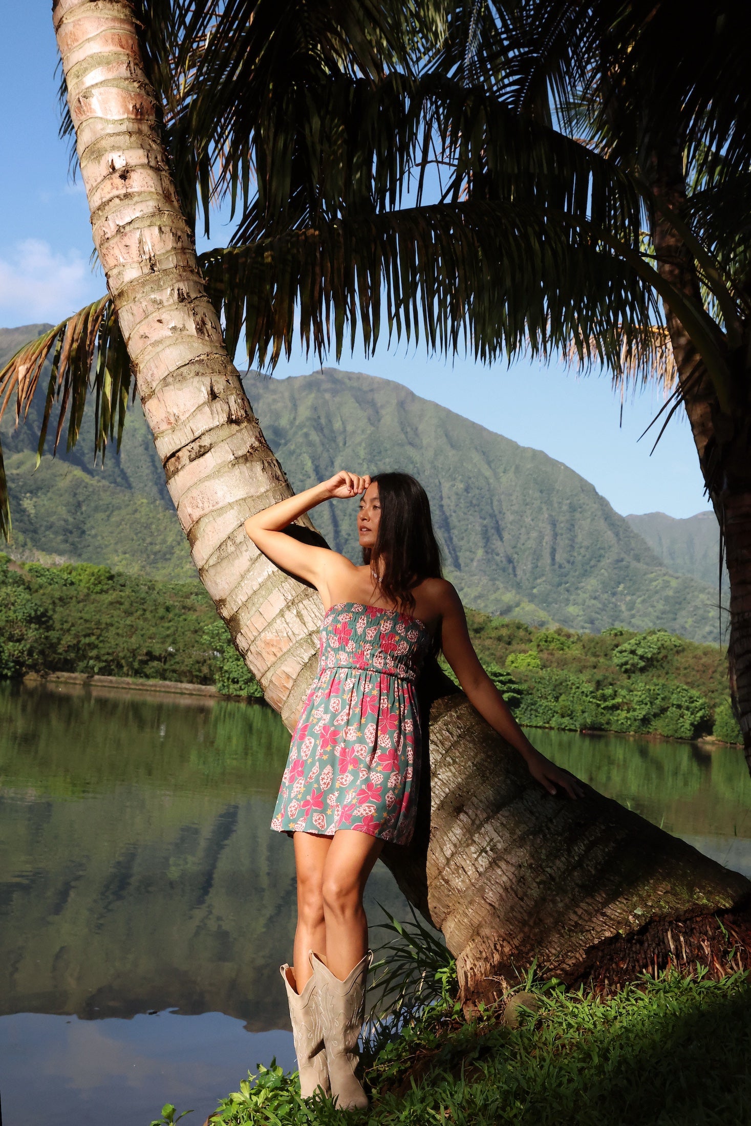woman with brown hair wearing a teal mini dress with removable straps and smocked bodice with shell and pua print