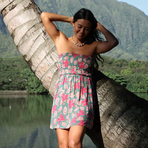 woman with brown hair wearing a teal mini dress with removable straps and smocked bodice with shell and pua print