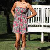 woman with brown hair wearing a teal mini dress with removable straps and smocked bodice with shell and pua print