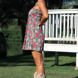 woman with brown hair wearing a teal mini dress with removable straps and smocked bodice with shell and pua print