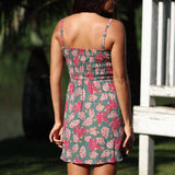 woman with brown hair wearing a teal mini dress with removable straps and smocked bodice with shell and pua print