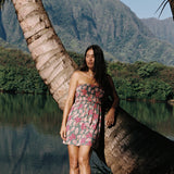 woman with brown hair wearing a teal mini dress with removable straps and smocked bodice with shell and pua print