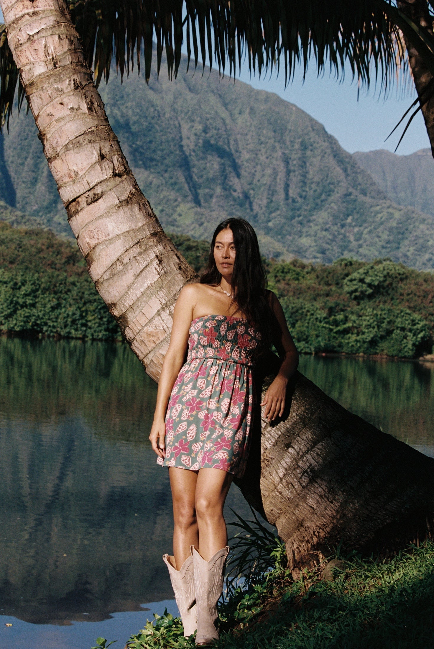 woman with brown hair wearing a teal mini dress with removable straps and smocked bodice with shell and pua print