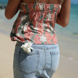 woman with blonde hair wearing jade colored tank top with tiare ginger print