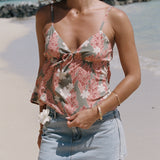 woman with blonde hair wearing jade colored tank top with tiare ginger print