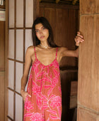 A woman with dark hair wears a YIREH v-neck, wide legged jumpsuit. It is the Laney Jumpsuit in the Garden 'Awapuhi print. 