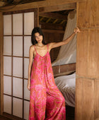 A woman with dark hair wears a YIREH v-neck, wide legged jumpsuit. It is the Laney Jumpsuit in the Garden 'Awapuhi print. 