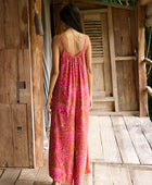 A woman with dark hair wears a YIREH v-neck, wide legged jumpsuit. It is the Laney Jumpsuit in the Garden 'Awapuhi print. 