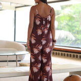 woman wearing simple brown spaghetti strap jumpsuit with protea print