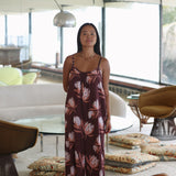 woman wearing simple brown spaghetti strap jumpsuit with protea print