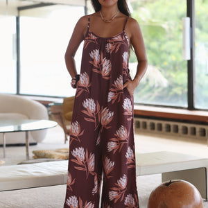 woman wearing simple brown spaghetti strap jumpsuit with protea print