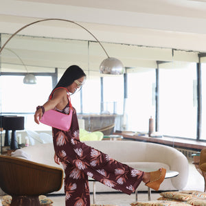 woman wearing simple brown spaghetti strap jumpsuit with protea print