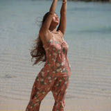 woman with brown hair wearing jade colored jumpsuit with tiare ginger print