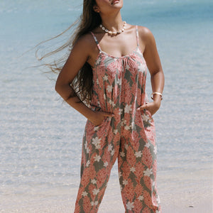 woman with brown hair wearing jade colored jumpsuit with tiare ginger print