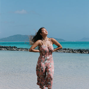 woman with brown hair wearing jade colored jumpsuit with tiare ginger print