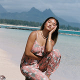 woman with brown hair wearing jade colored jumpsuit with tiare ginger print