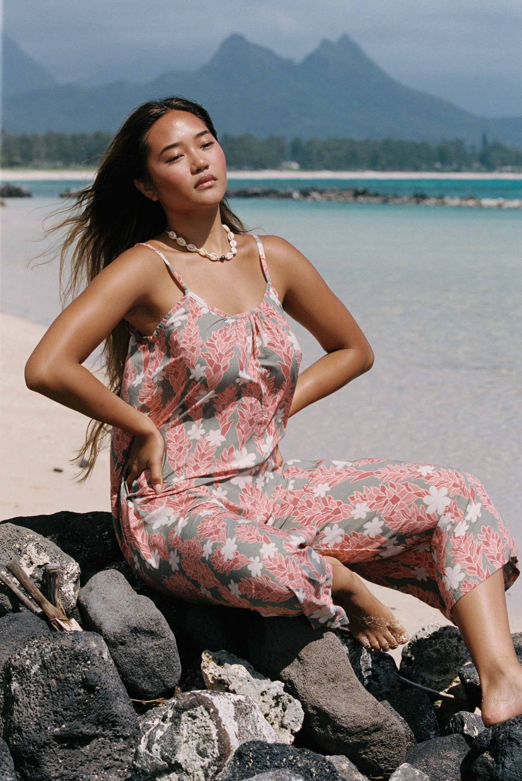 woman with brown hair wearing jade colored jumpsuit with tiare ginger print