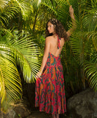 woman with brown hair wearing a colorful flowy maxi dress with tropical lei print