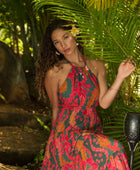 woman with brown hair wearing a colorful flowy maxi dress with tropical lei print