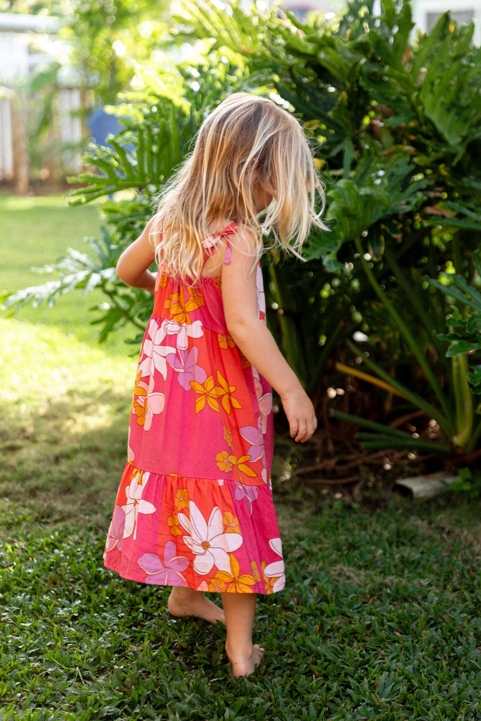 little girl wearing a pink tie strap maxi dress with retro flower pattern