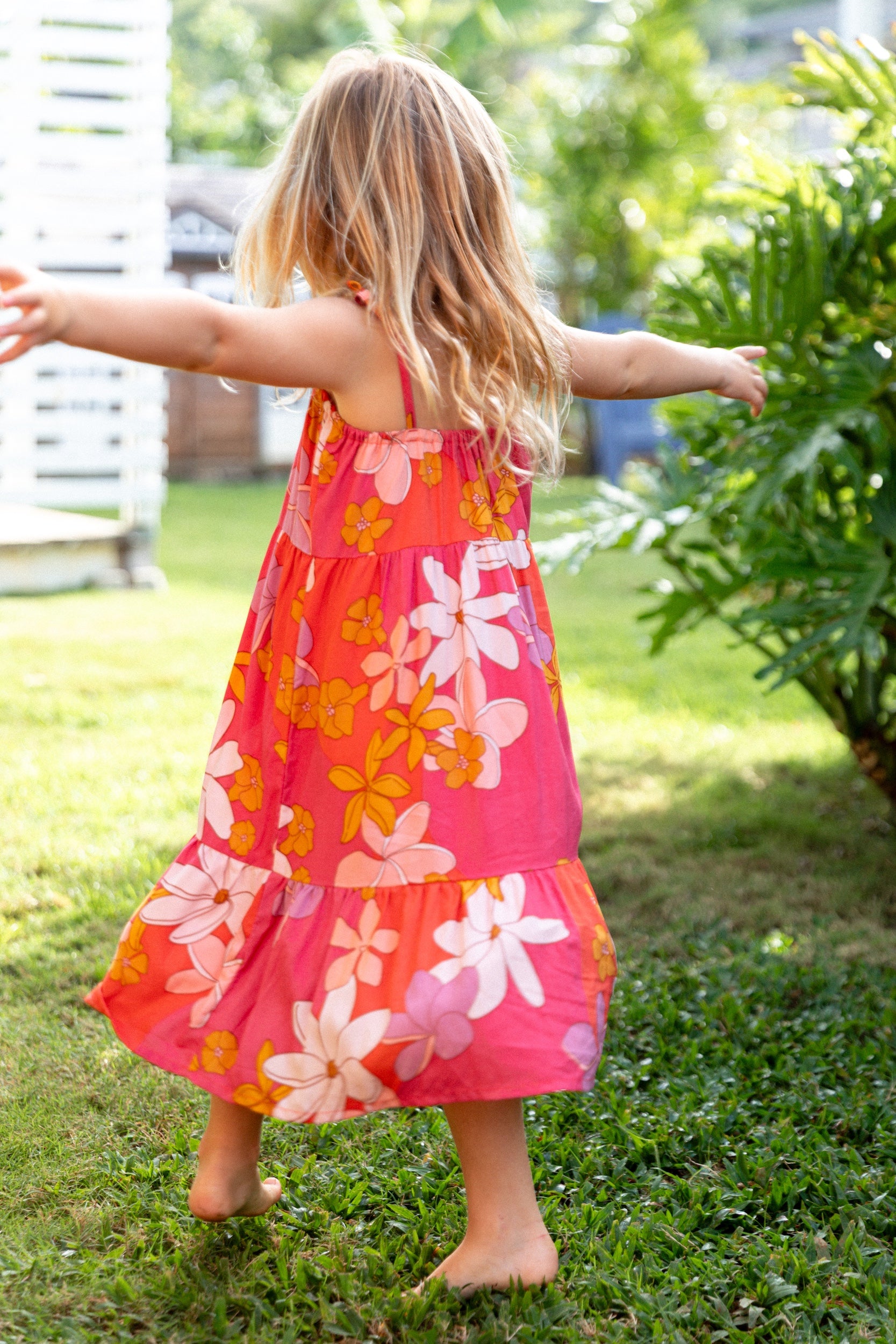 little girl wearing a pink tie strap maxi dress with retro flower pattern