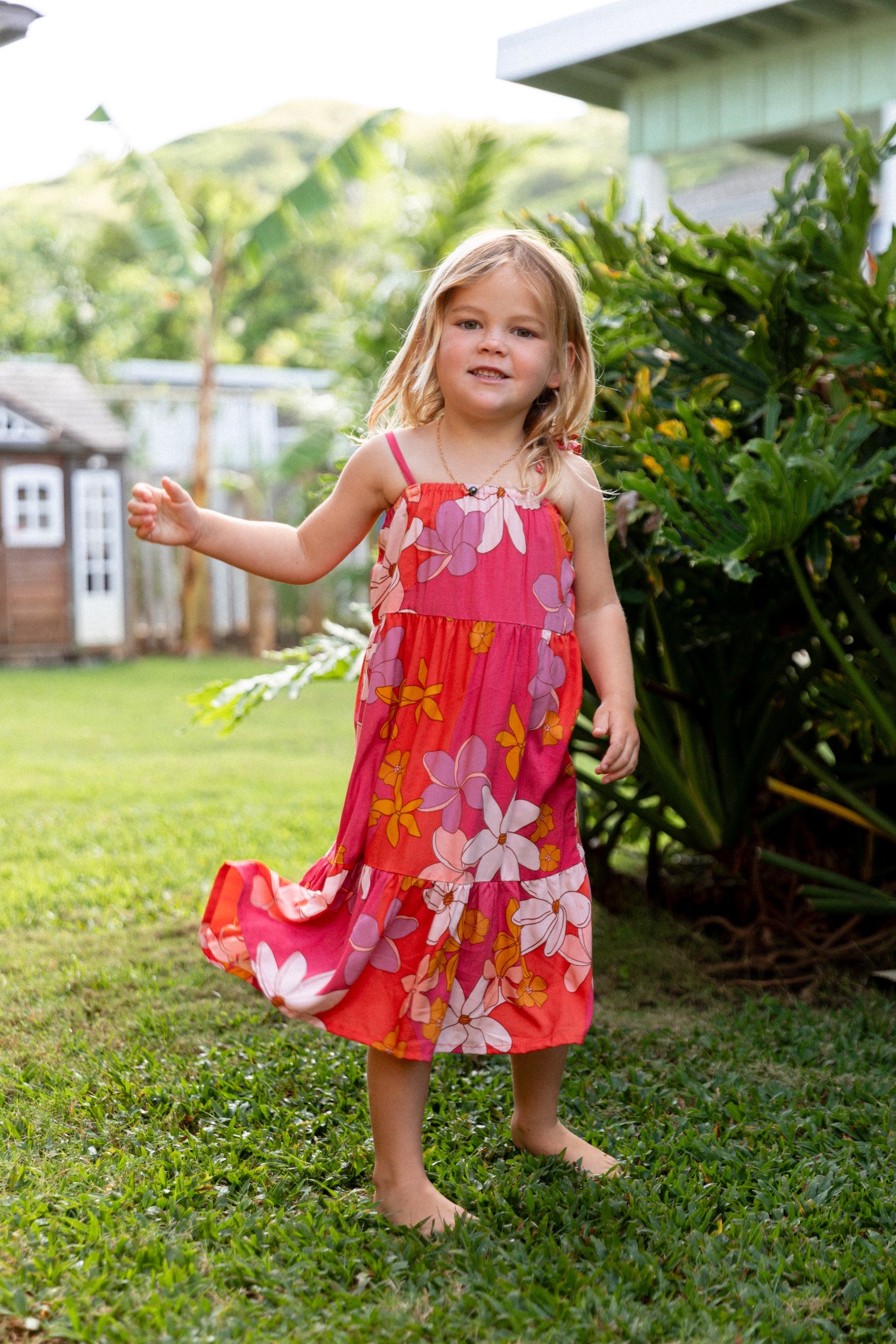 little girl wearing a pink tie strap maxi dress with retro flower pattern