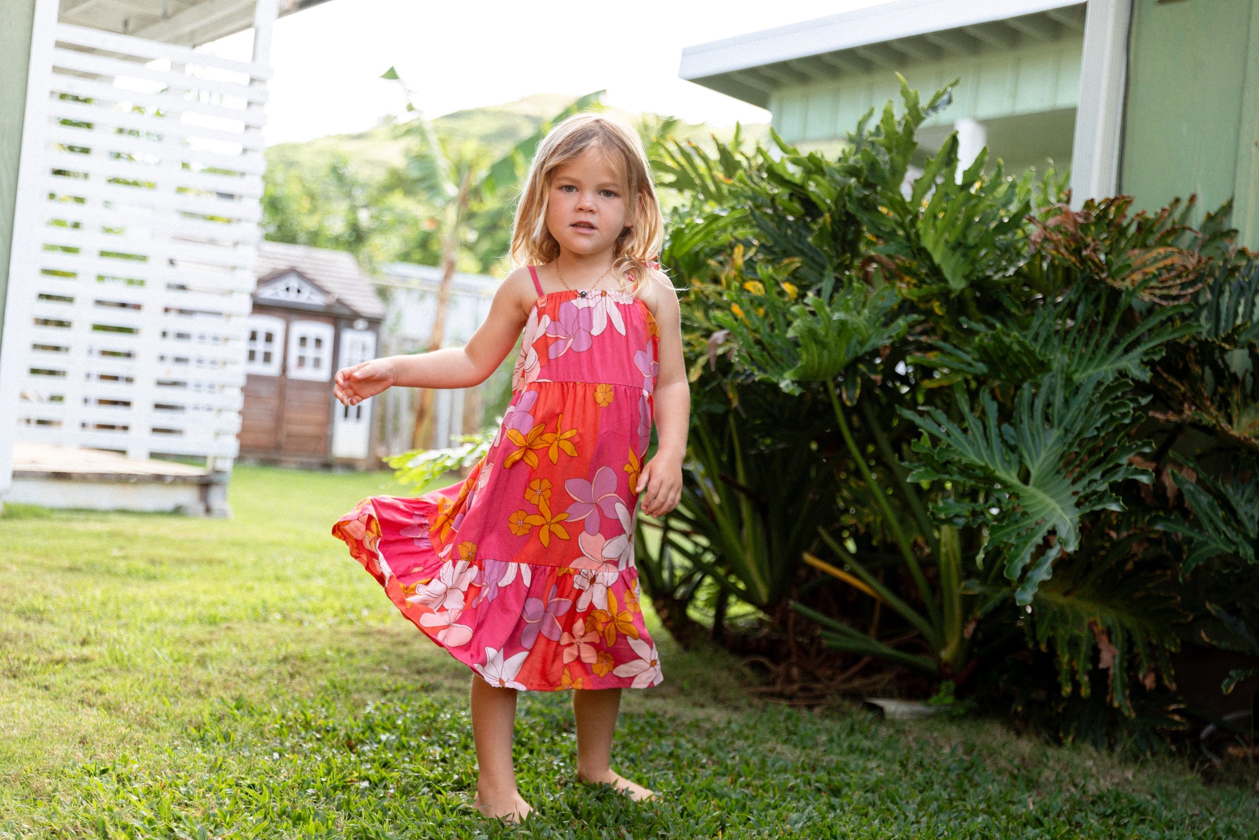 little girl wearing a pink tie strap maxi dress with retro flower pattern