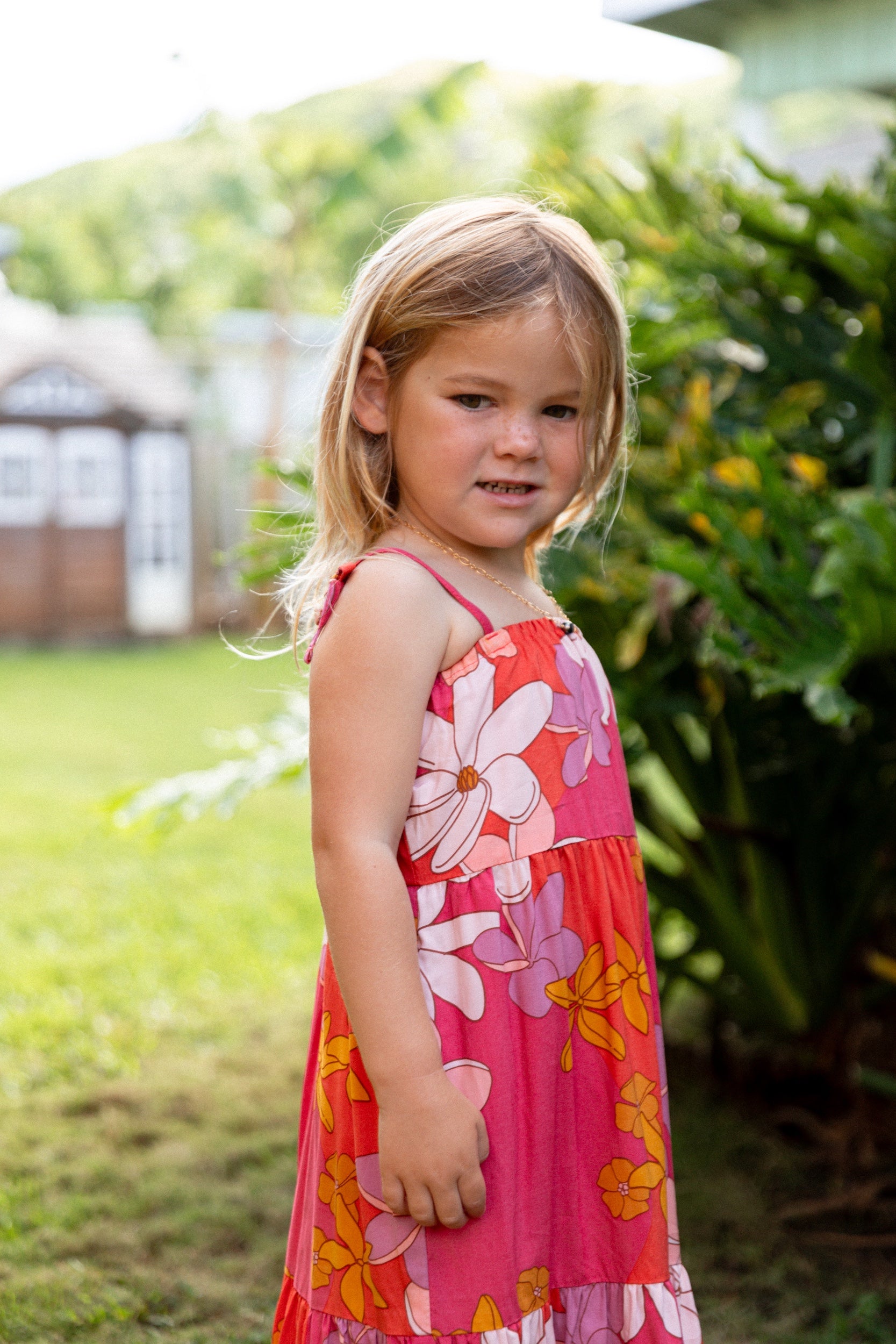 little girl wearing a pink tie strap maxi dress with retro flower pattern