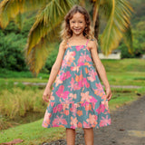 little girl wearing long teal dress with tie sleeve and floral pattern