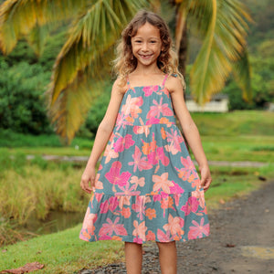 little girl wearing long teal dress with tie sleeve and floral pattern