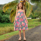 little girl wearing long teal dress with tie sleeve and floral pattern