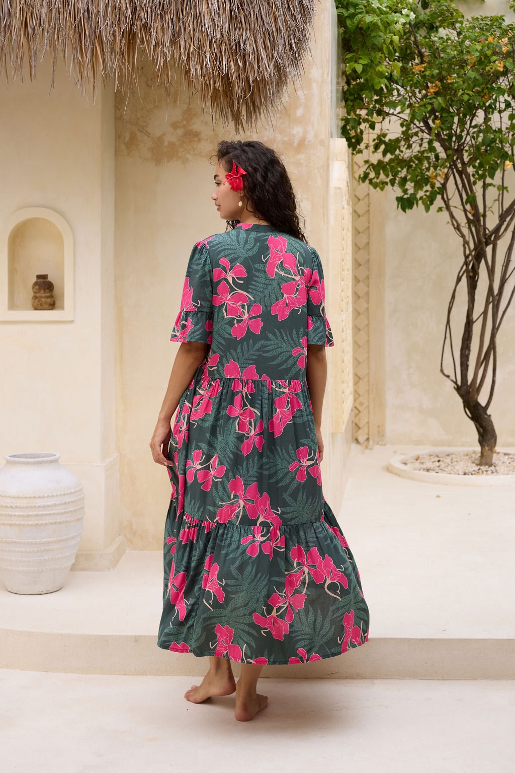 woman with brown hair wearing a dark green half sleeve, oversized maxi dress with button closure, with fern and ginger print