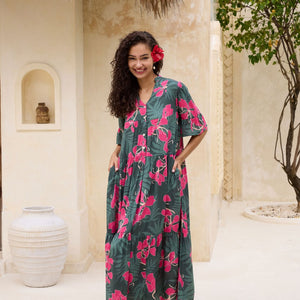 woman with brown hair wearing a dark green half sleeve, oversized maxi dress with button closure, with fern and ginger print