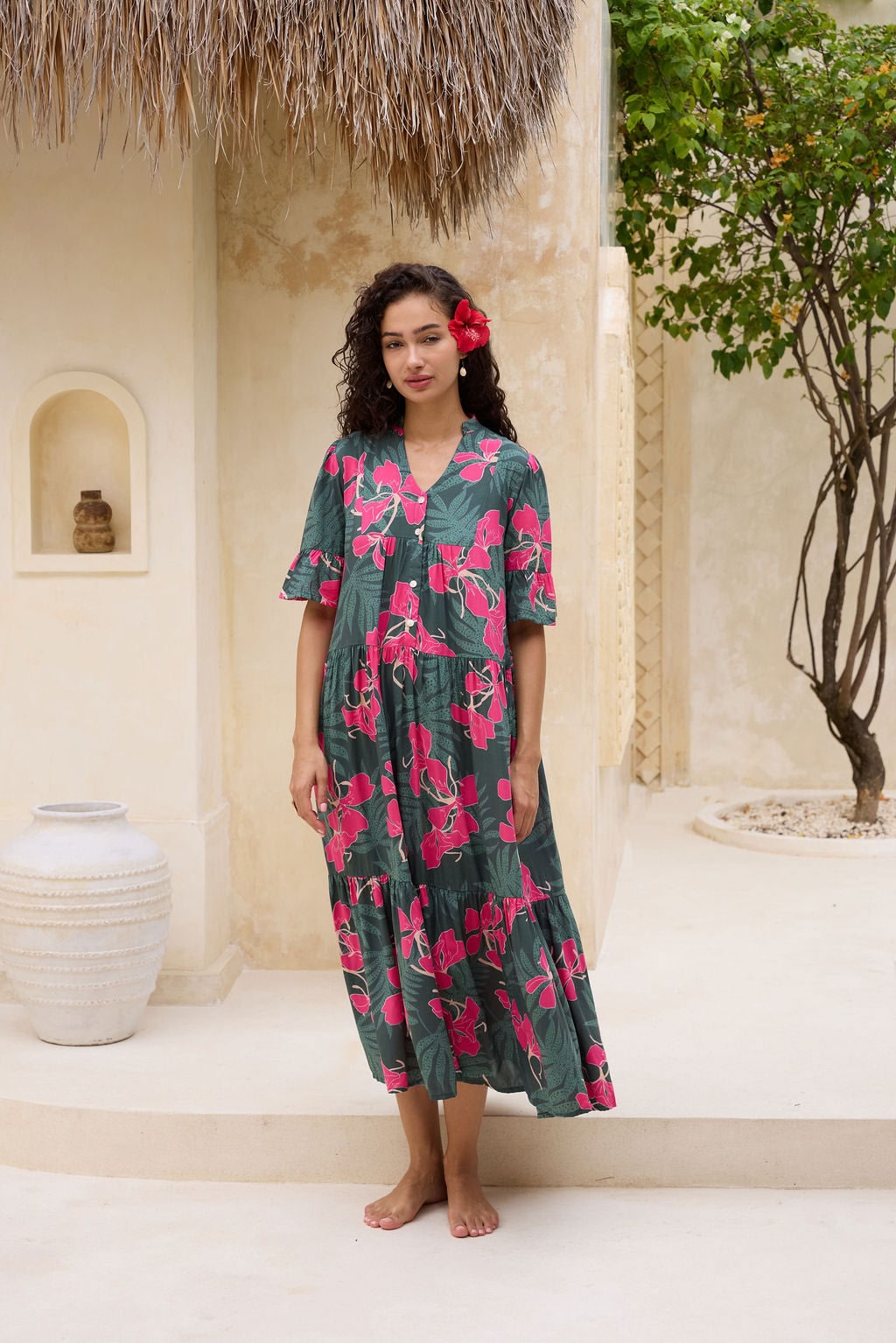 woman with brown hair wearing a dark green half sleeve, oversized maxi dress with button closure, with fern and ginger print