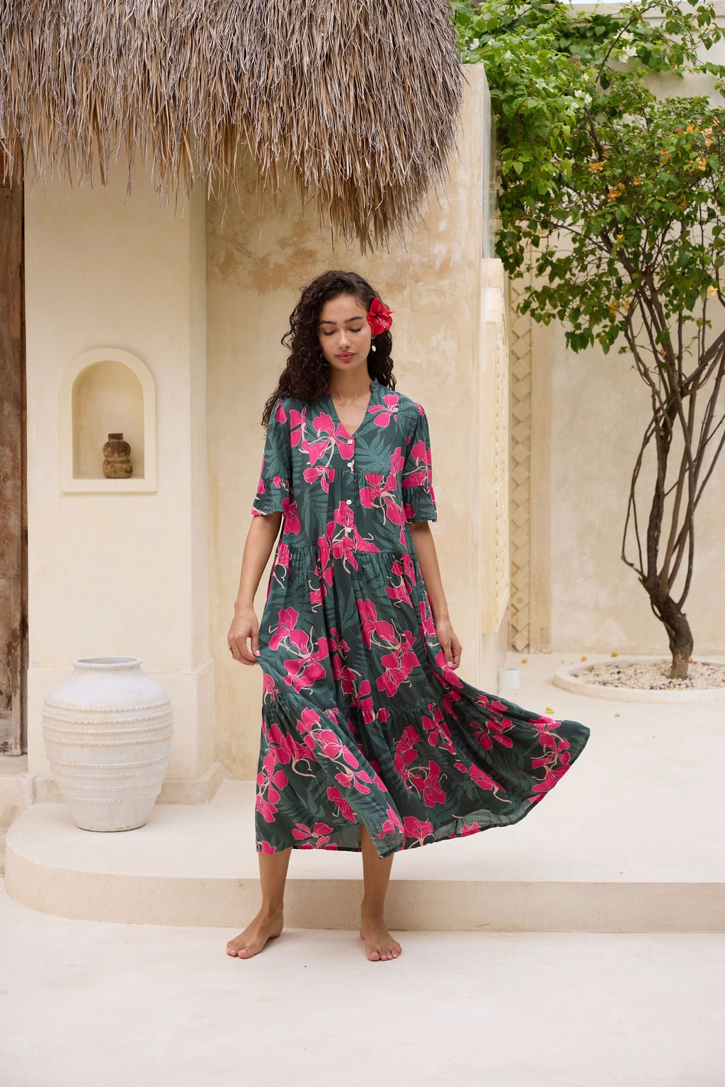 woman with brown hair wearing a dark green half sleeve, oversized maxi dress with button closure, with fern and ginger print