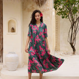 woman with brown hair wearing a dark green half sleeve, oversized maxi dress with button closure, with fern and ginger print