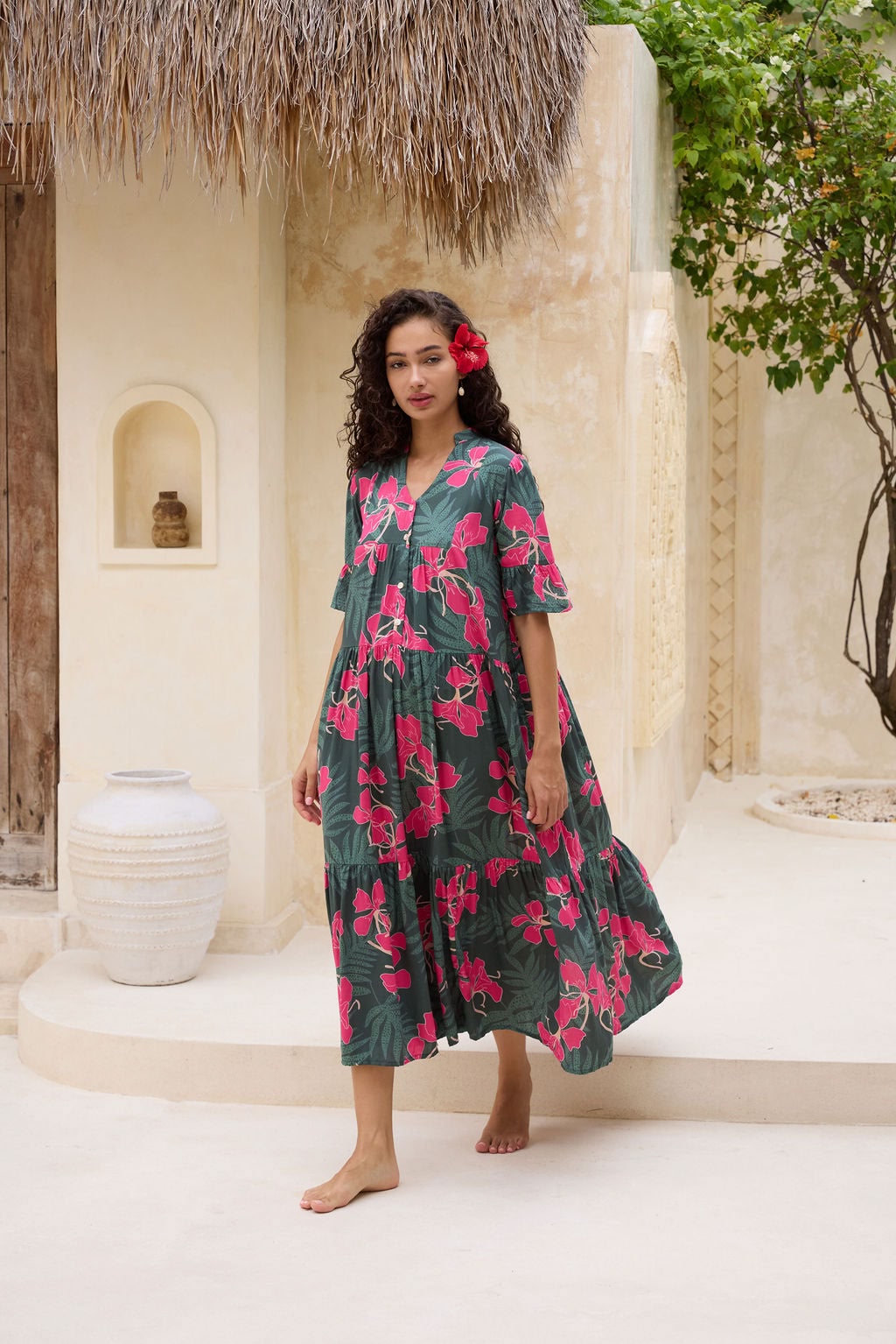woman with brown hair wearing a dark green half sleeve, oversized maxi dress with button closure, with fern and ginger print