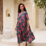 woman with brown hair wearing a dark green half sleeve, oversized maxi dress with button closure, with fern and ginger print