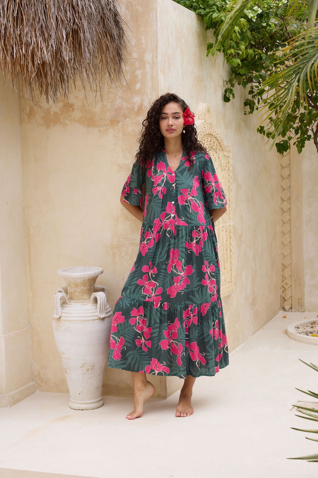 woman with brown hair wearing a dark green half sleeve, oversized maxi dress with button closure, with fern and ginger print