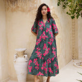 woman with brown hair wearing a dark green half sleeve, oversized maxi dress with button closure, with fern and ginger print