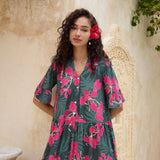 woman with brown hair wearing a dark green half sleeve, oversized maxi dress with button closure, with fern and ginger print