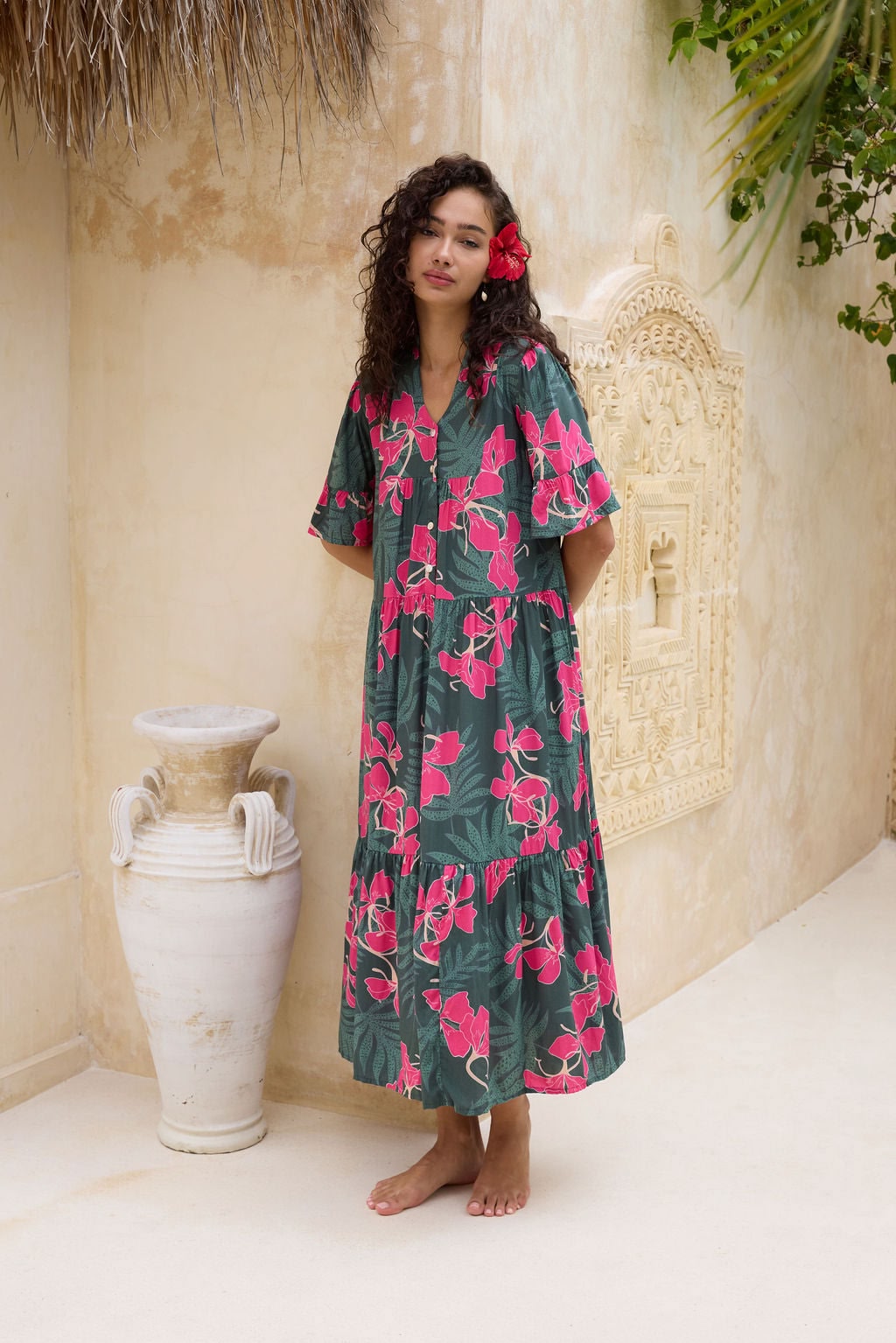 woman with brown hair wearing a dark green half sleeve, oversized maxi dress with button closure, with fern and ginger print